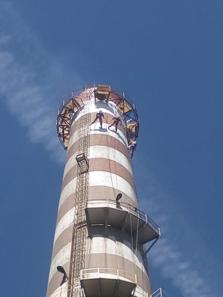 Técnicos verticales preparando la superficie de la chimenea para pintar