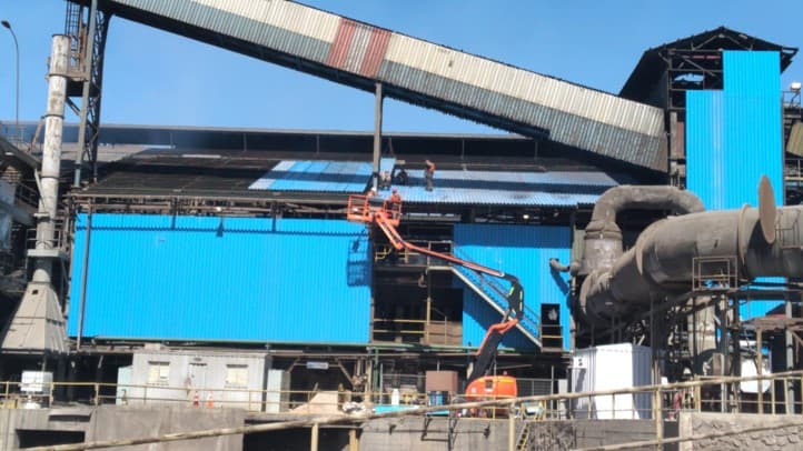 Cuadrilla operando desde alza hombre en fachada de planta