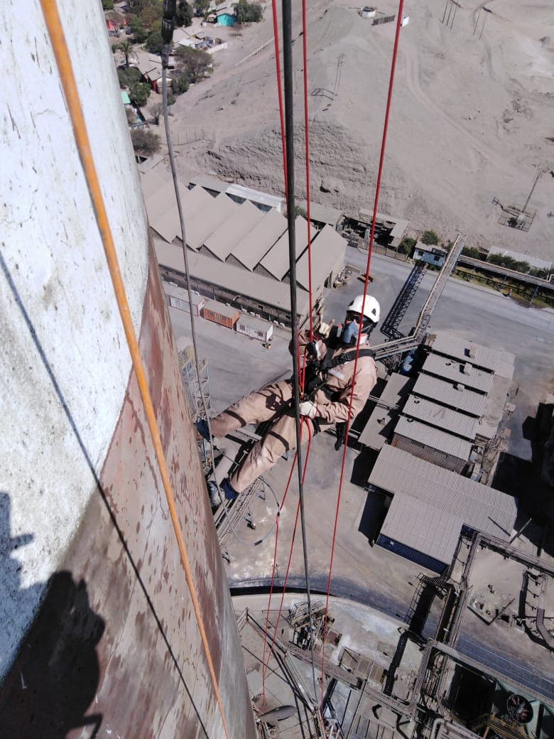 Técnico vertical limpiando la estructura de la chimenea a más de 40 metros